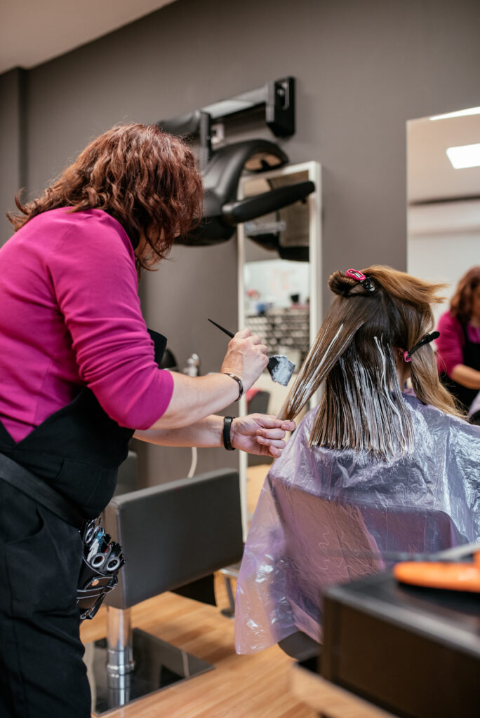 hairdresser dyeing a woman's hair